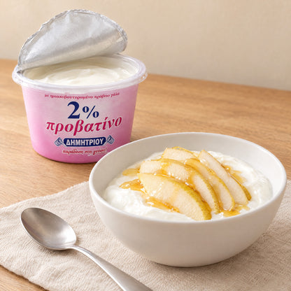 Schale Schafsjoghurt mit Birnenscheiben und Honig neben einem geöffneten Dimitriou-Becher