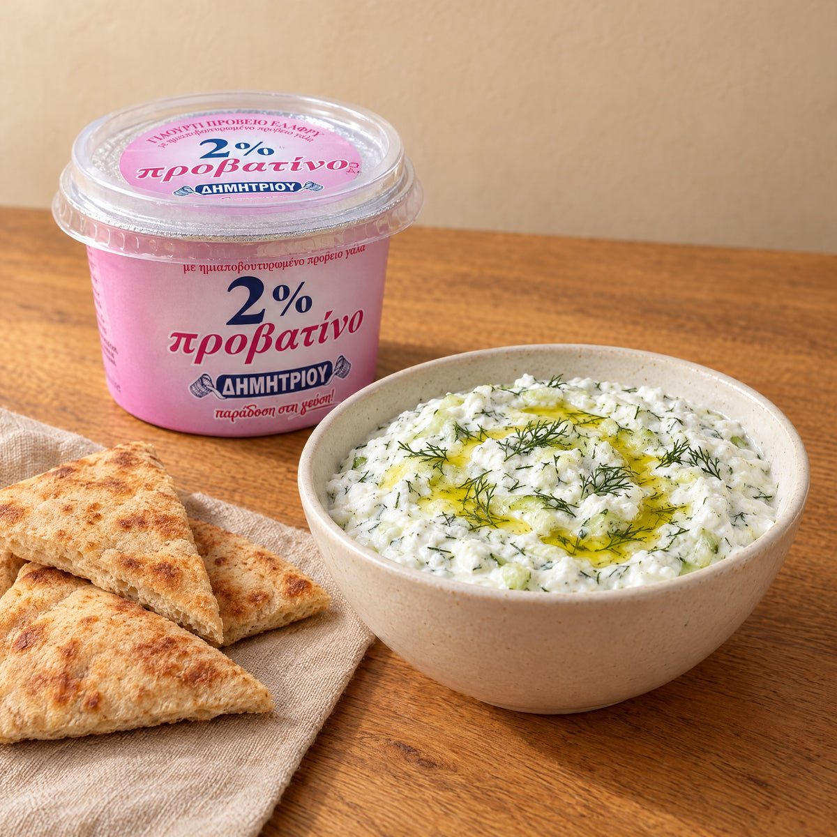 Tzatziki mit Dill und Olivenöl, Pita-Dreiecke und ein Becher Dimitriou Schafsjoghurt