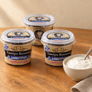 Trois pots de yaourt de chèvre Dimitriou, dont un avec la chèvre sur l'étiquette, à côté d'un bol de yaourt blanc
