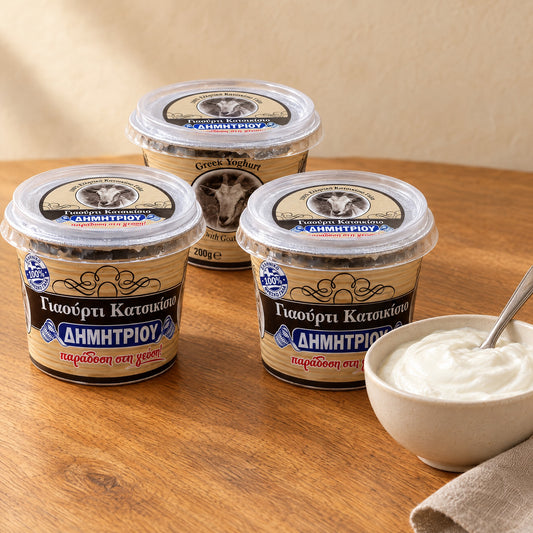 Three cups of Dimitriou goat yogurt, one with the goat on the label, next to a bowl of white yogurt