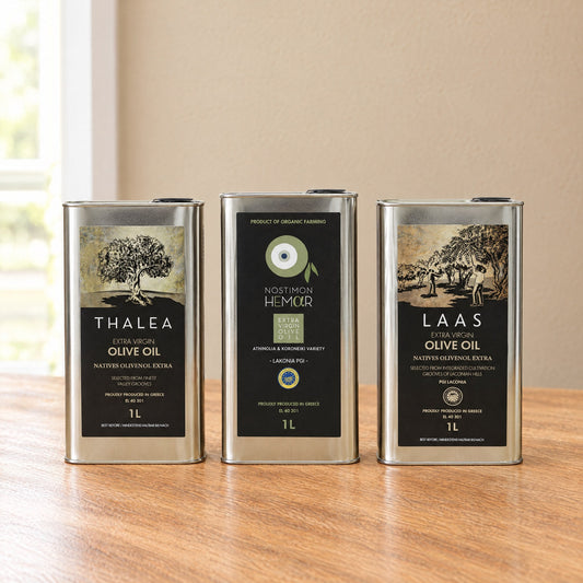 Thalea, Nostimon Hemar and Laas PGI extra virgin olive oil 1L tins by Energaea, side by side on an oak table