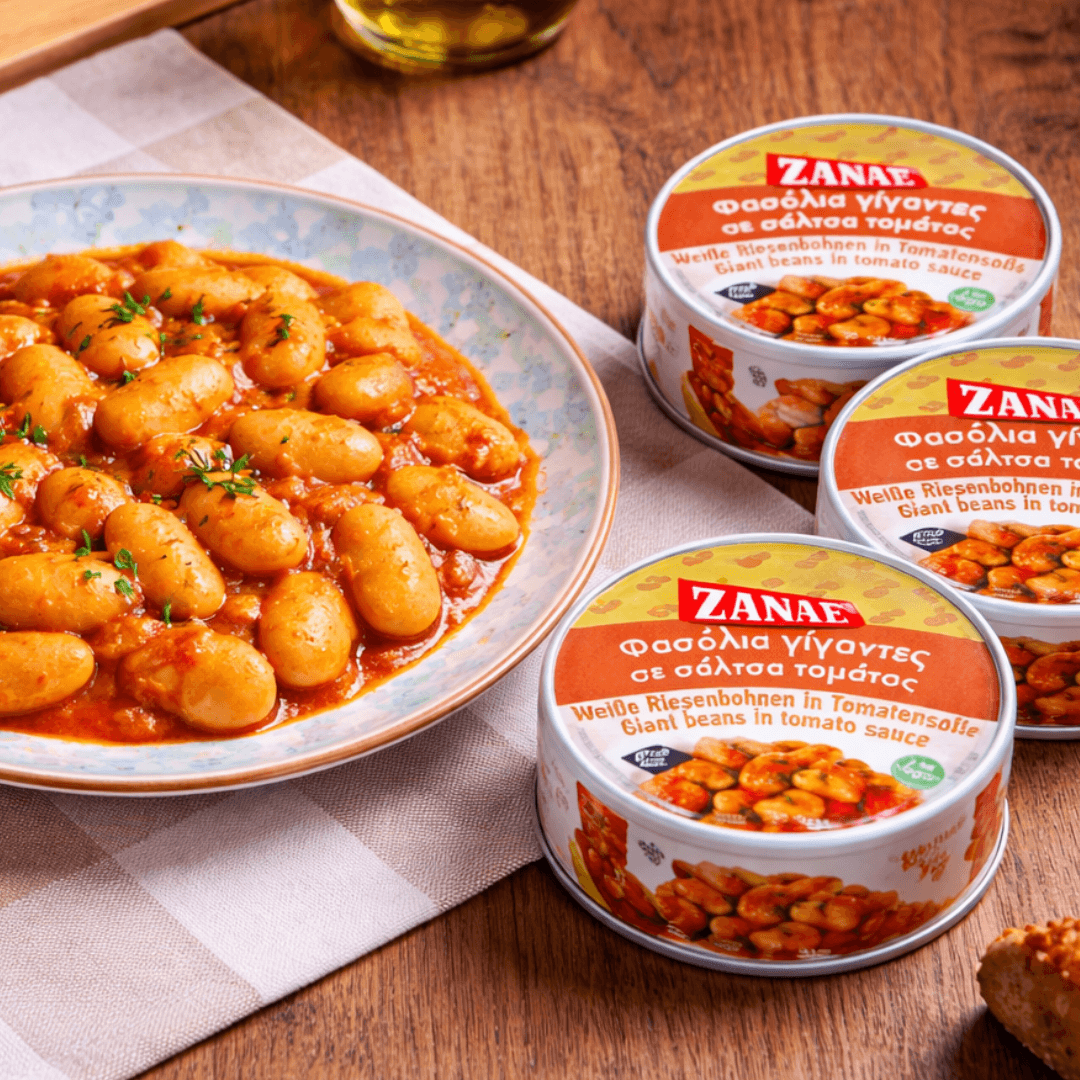 Zanae gigantes beans in tomato sauce on a plate with the round tins