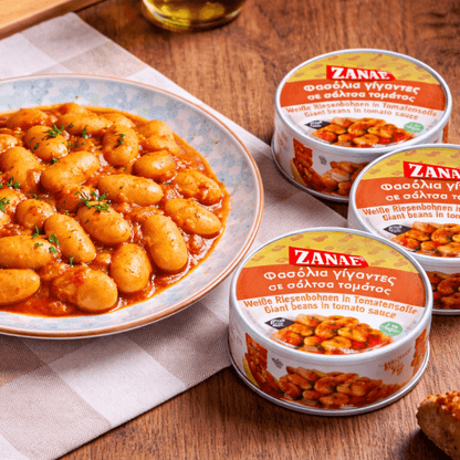 Zanae gigantes beans in tomato sauce on a plate with the round tins