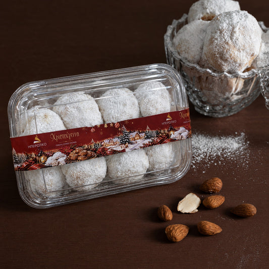 Kourabiedes dans la barquette scellée Ipirotiko de 320 g avec sa bande de Noël, à côté d'amandes
