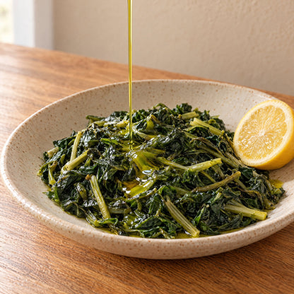 Extra virgin olive oil poured over boiled greens with lemon