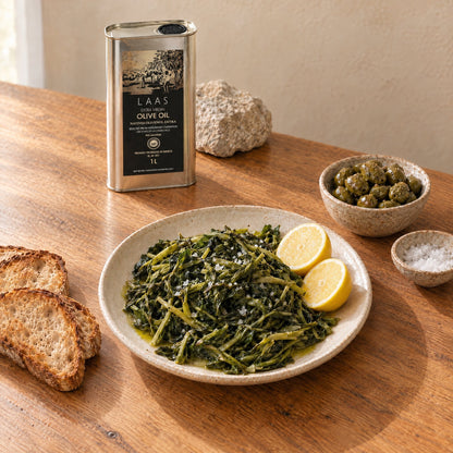 Boiled greens, bread and green olives with the Laas 1L tin on a kitchen table