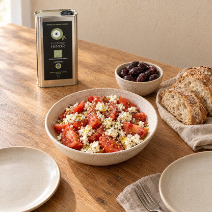 A table for two with tomato and feta salad, bread, olives and the Nostimon Hemar 1L tin