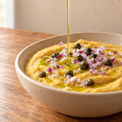 Extra virgin olive oil drizzled over fava split pea purée with red onion and capers
