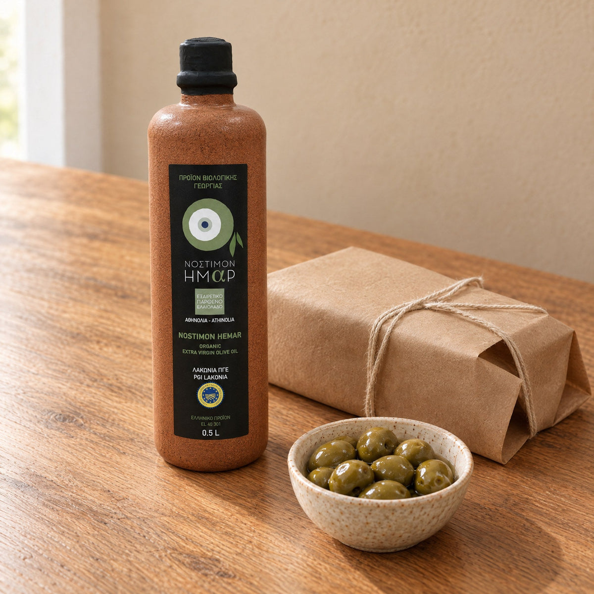 The Nostimon Hemar ceramic bottle beside a parcel wrapped in plain brown paper