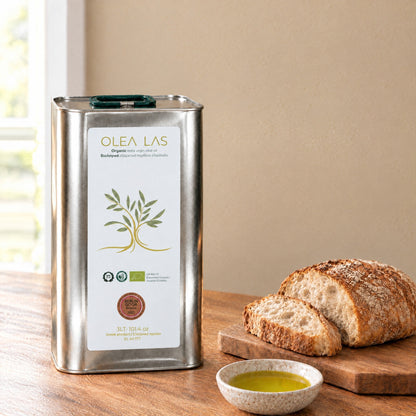 Huile d'olive vierge extra bio Olea Las en bidon de 3L sur une table de cuisine avec du pain et une coupelle d'huile