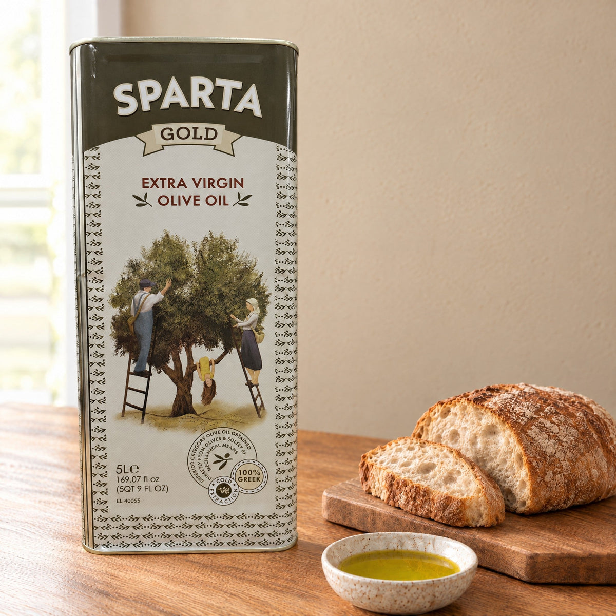 Sparta Gold extra virgin olive oil 5L tin on a kitchen table with bread and a dish of olive oil