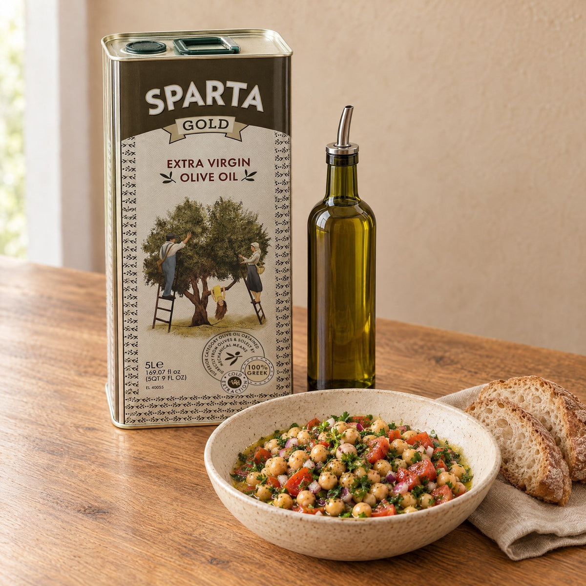 The Sparta Gold 5L tin next to a small bottle of olive oil for everyday use, with a chickpea salad