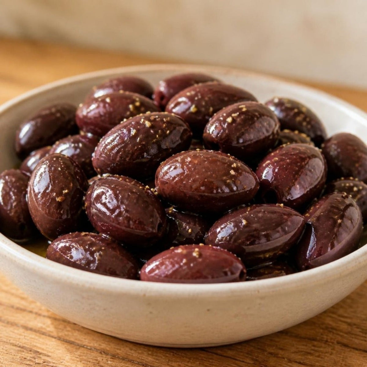 Primer plano de aceitunas de Kalamata enteras con aceite de oliva y orégano seco en un cuenco de cerámica