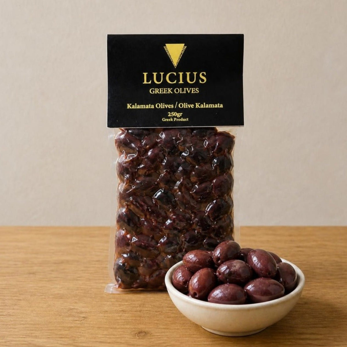 Bolsa de aceitunas de Kalamata Lucius de 250g con un cuenco pequeño de aceitunas enteras